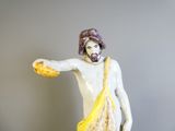 une figurine représentant un homme avec un sac sur l'épaule