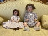 two dolls that are sitting on a couch together