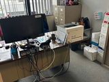 un bureau avec un ordinateur et une imprimante dans un coin de la pièce