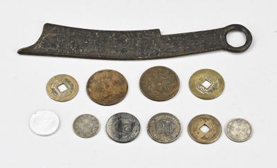 plusieurs types de pièces de monnaie et un couteau posés sur une surface blanche