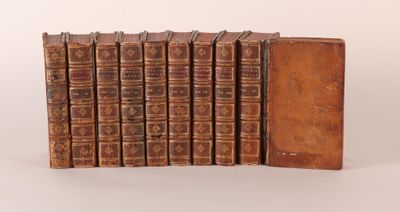six old books are stacked on top of each other on a white surface