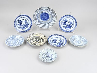 un assortiment d'assiettes et de bols bleus et blancs posés sur une surface blanche