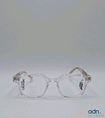 des lunettes à monture transparente posées sur une surface blanche, sur fond blanc