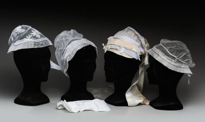 trois têtes de mannequins coiffées de chapeaux, exposées sur une table