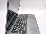 a silver laptop with a black keyboard on a white surface