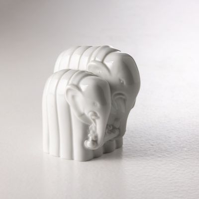 une figurine d'éléphant blanc posée sur une surface blanche