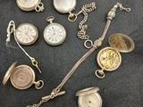 many different types of pocket watches on the table