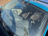 a blue car parked on the side of the road with a crane on top of it
