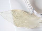 a necklace with a glass angel on it on a mannequin