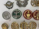 some of the badges are gold and silver on a white surface
