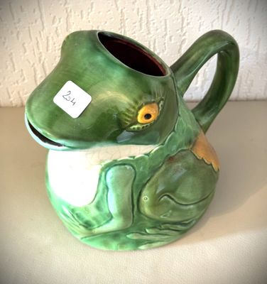 un vase en forme de grenouille verte, muni d'une étiquette