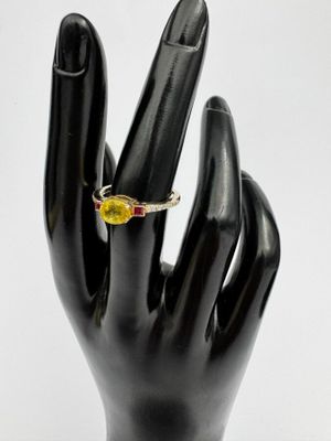 Bague en saphir jaune et diamants, posée sur la main noire d'un mannequin