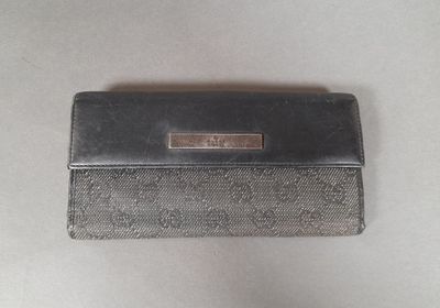 a close up of a black and silver purse on a white surface