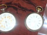 deux horloges posées sur un tissu rouge