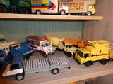 de nombreux camions miniatures posés sur une étagère dans une pièce