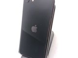 a black iphone sitting on a stand on a white surface