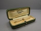 a small box with a tie bar inside of it