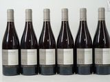 six bottles of wine are lined up in a row on a table