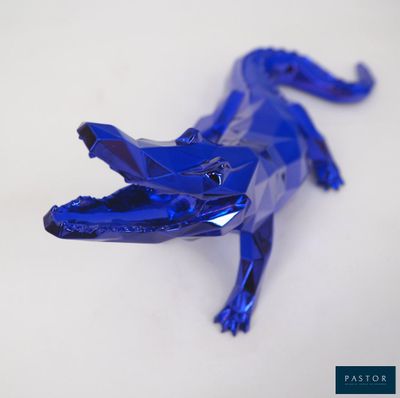 un alligator en plastique bleu posé sur une table