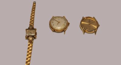three watches and a watch bracelet on a table