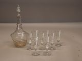 des bouteilles et des verres posés sur une table, avec une carafe en arrière-plan