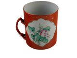 un gobelet rouge orné d'un motif floral