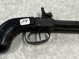 un gros plan d'un pistolet posé sur une table, avec une étiquette dessus