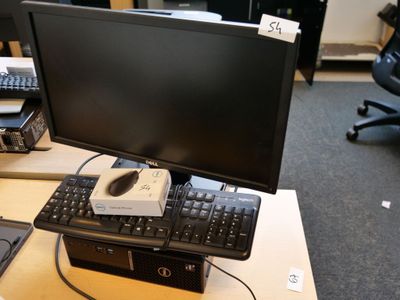 un écran d'ordinateur posé sur un bureau, avec un clavier et une souris