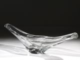 un saladier en verre posé sur une table, sur fond noir