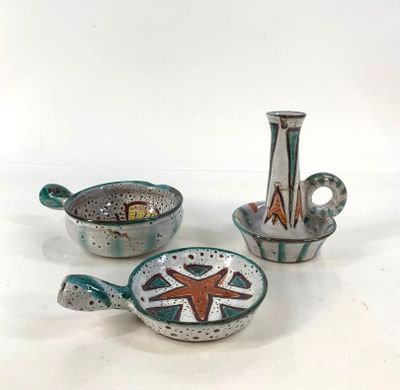 trois pièces de poterie posées sur une table