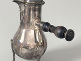 a silver coffee pot with a wooden handle on a stand