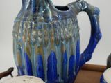 a blue and white pitcher and two cups on a tray