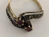 a close up of a gold and silver ring with purple stones