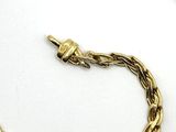 an image of a close up of a gold necklace on a white surface