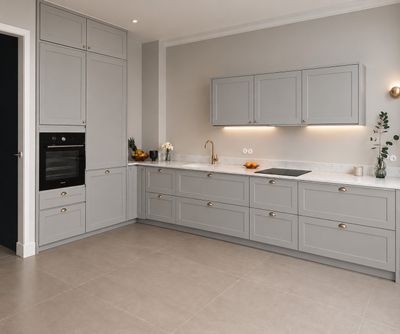 a large kitchen with grey cabinets and white counter tops