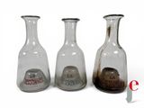 three glass vases that are sitting next to each other