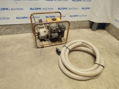 a hose that is sitting on the ground next to a water pump