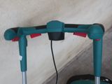 a green and red scooter with a handle attached to it