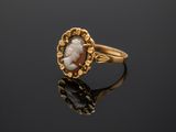 an image of a gold ring with a cameo cameo in the center