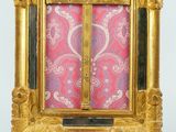 an ornate gold frame with a cross on top of it