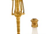 un bougeoir doré et une bouteille en verre sur fond blanc