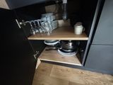 a black cupboard with plates and glasses on it