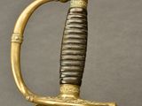 an old sword with a gold handle on a gray background