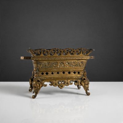 an antique brass candle holder on a white surface with a black background