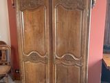 une grande armoire en bois dans le coin d'une pièce