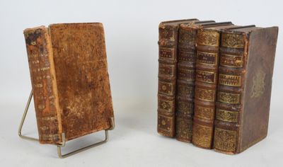 paire de livres anciens reliés en cuir, posés sur un support métallique