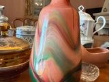 a colorful vase sitting on a table in a room