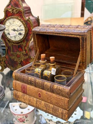 une petite boîte en bois contenant des bouteilles, posée sur une table en verre