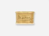 un gros plan d'une bague en or sur laquelle figure une inscription