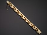 a gold bracelet with a chain on a black background